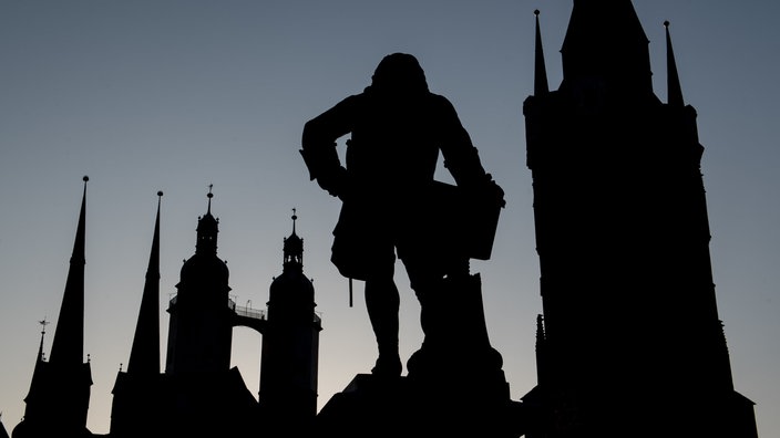 In der Dämmerung zeichnet sich die Silhouette des Marktes von Halle ab: mit der Marktkirche, dem Roten Turm und dem Denkmal für Georg Friedrich Händel. 