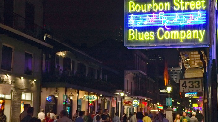 Menschen drängen sich durch die Bourbon Street in New Orleans.