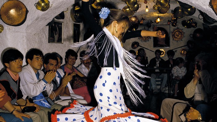 Tänzerin in einer Flamenco-Bar, begleitet von klatschenden Zuschauern