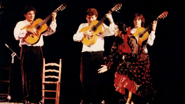 Flamenco-Tänzerin vor drei Gitarristen