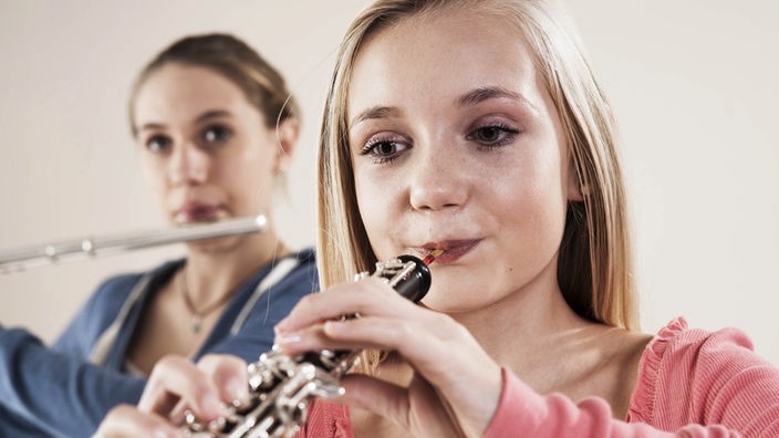 Zwei Teenager spielen auf Blasinstrumenten.