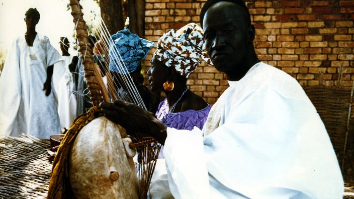 Ein Musiker in Gambia spielt das Nationalinstrument Kora.