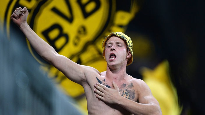 Ein Borussia Dortmund Ultra Fan auf dem Zaun der der Allianz Arena in München