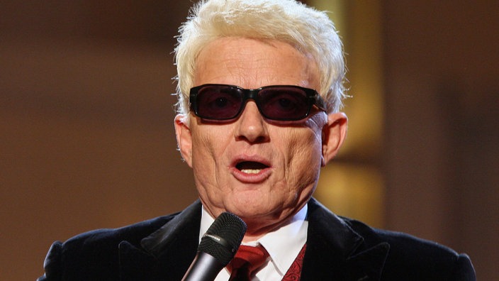 Der Sänger Heino mit Mikro bei einer Gala 2006 | Bildquelle: picture alliance / ASSOCIATED PRESS / ECKEHARD SCHULZ Der Sänger Heino mit Mikro bei einer Gala 2006