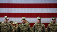 US-Soldaten vor amerikanischer Flagge.