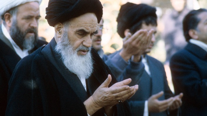 Ayatollah Khomeini bei einem Gebet im Exil in Pontchartrain (1978). | Bildquelle: Imago Ayatollah Khomeini bei einem Gebet im Exil in Pontchartrain (1978).