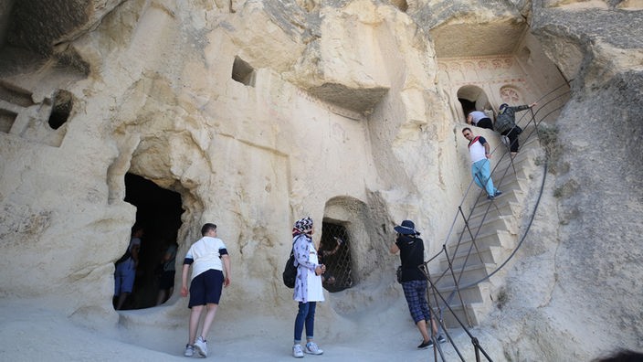 Touristen steigen über schmale Treppen ab