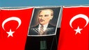 Zwischen zwei türkischen Fahnen hängt ein Porträt von Atatürk
