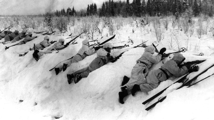 Finnische Truppen in Schneeuniformen gehen im sogenannten Winterkrieg an der Frontlinie in Stellung und greifen russische Positionen an