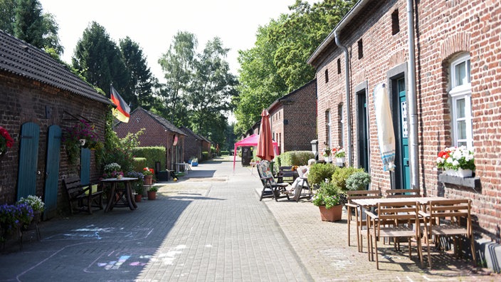 Vor Häsern stehen Bänke und Stühle. | Bildquelle: dpa/Caroline Seidel Vor Häsern stehen Bänke und Stühle.