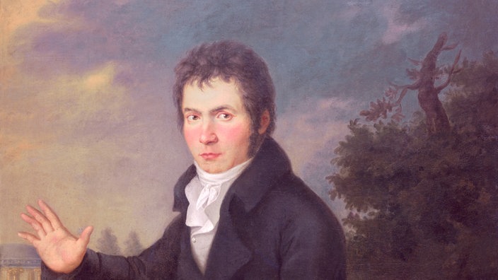 Das Gemälde zeigt den jungen Beethoven. Zu sehen ist im Vordergrund ein ernst blickender, dunkel gekleideter und dunkelhaariger junger Mann, der sitzend zum Betrachter schaut und den rechten Arm von sich streckt. | Bildquelle: akg Das Gemälde zeigt den jungen Beethoven. Zu sehen ist im Vordergrund ein ernst blickender, dunkel gekleideter und dunkelhaariger junger Mann, der sitzend zum Betrachter schaut und den rechten Arm von sich streckt.