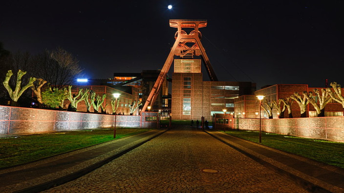 Die Zeche Zollverein beleuchtet bei Nacht.