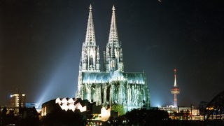 Blick auf die Stadt mit Kölner Dom, Fernsehturm und Philharmonie bei Nacht.