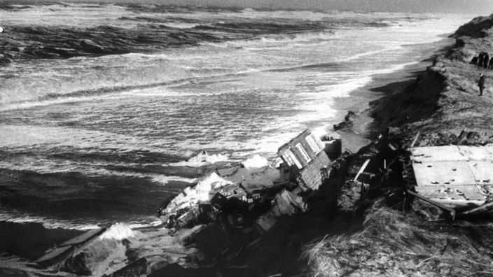 Schwarzweiß-Foto von einem Haus auf Sylt, das bei der Sturmflut von 1962 ins Meer gestürzt ist.