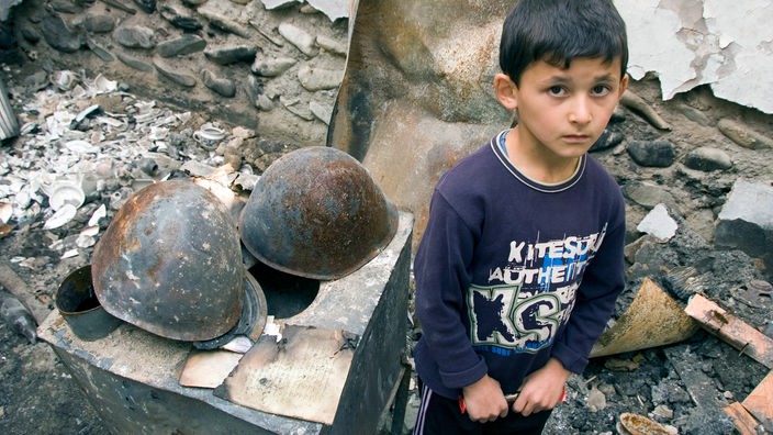 Ein kleiner Junge in seinem verbrannten Elternhaus 2008