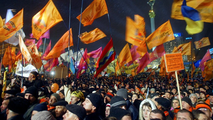 Menschenmenge bei Nacht mit orangefarbenen Fahnen. | Bildquelle: ddp Menschenmenge bei Nacht mit orangefarbenen Fahnen.
