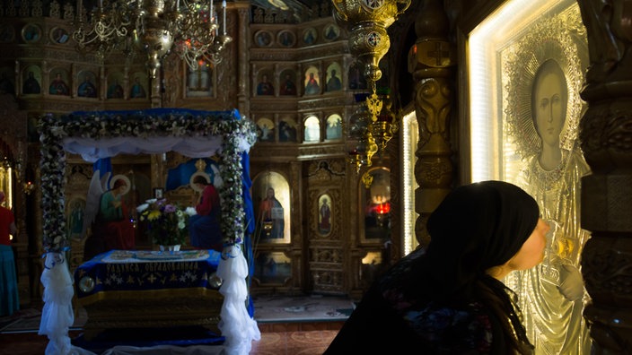 Eine Nonne küsst eine Ikone im Dreifaltigkeitskloster Saharna (Republik Moldau) | Bildquelle: picture alliance / Caro / Bastian Eine Nonne küsst eine Ikone im Dreifaltigkeitskloster Saharna (Republik Moldau)