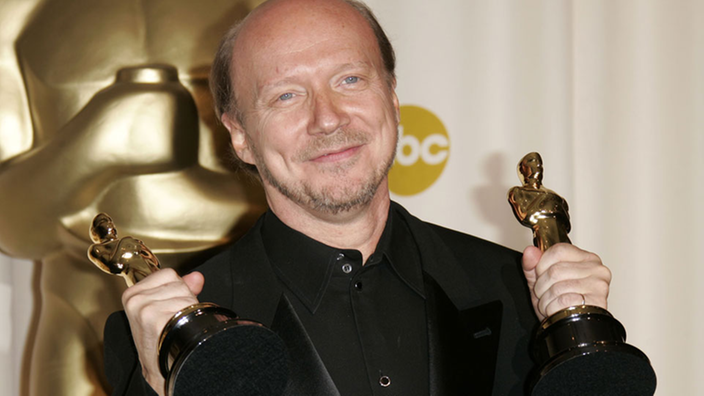 Drehbuchautor Paul Haggis hält zwei Oscar-Auszeichnungen hoch.