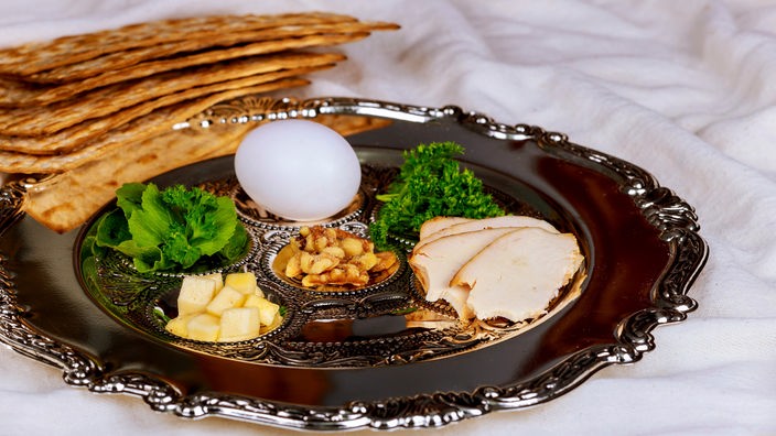 Ein silberner Seder-Teller mit Fleisch, Ei und Kräutern