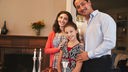 Eine jüdische Familie am Tisch mit Sabbatkerzen und Challa-Brot