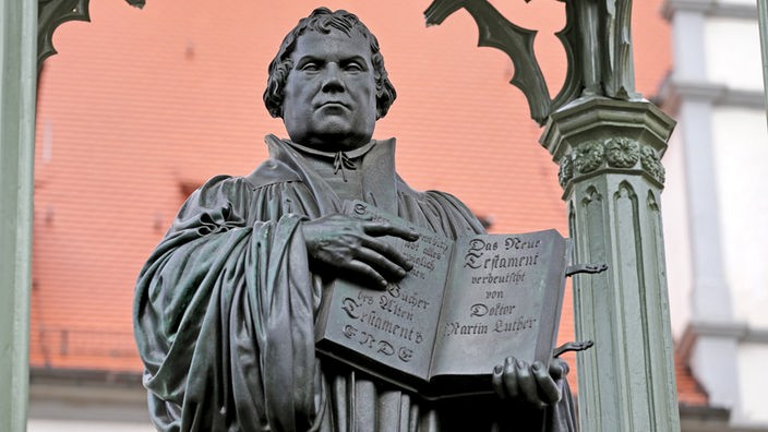 Das Denkmal Martin Luthers "hält" ein Neues Testament in Lutherstadt Wittenberg in den Händen