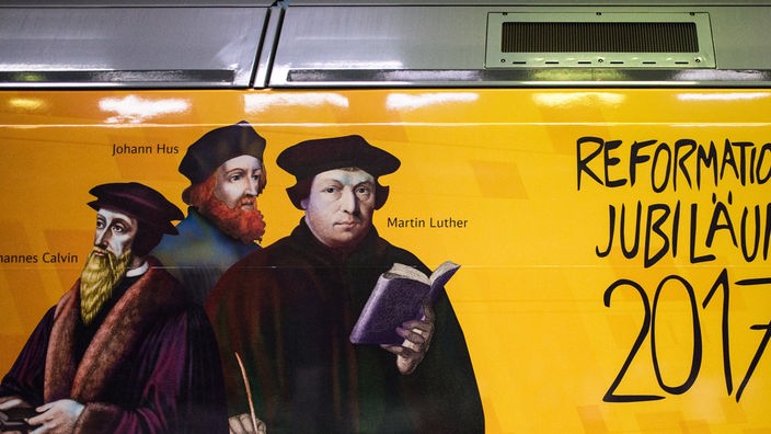 Aufschrift auf einem Zugwagon "Reformations Jubiläum 2017". Daneben die Bilder der Reformatoren Johannes Hus, Martin Luther und Johannes Calvin.
