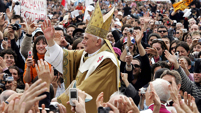 Der Papst in festlicher Kluft inmitten einer großen Menschenmenge.