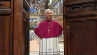 Ein Kardinal schließt große Holztüren zur Sixtinischen Kapelle.