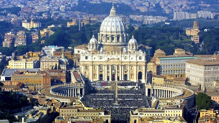 Blick von oben auf den Petersdom und den überfüllten Platz. | Bildquelle: dpa Picture-Alliance/Vincenco Corragio Blick von oben auf den Petersdom und den überfüllten Platz.