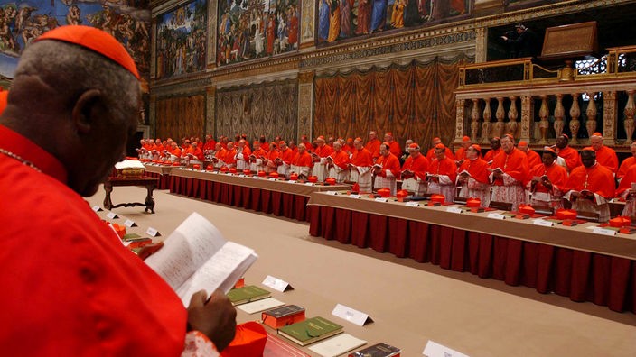 Zahlreiche rot gekleidete Kardinäle in der Sixtinischen Kapelle