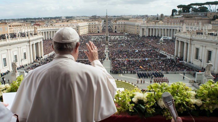 Papst Franziskus grüßt vom Balkon des Petersdom in eine große Menschenmenge