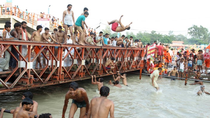 Gläubige Hindus springen in den Ganges.
