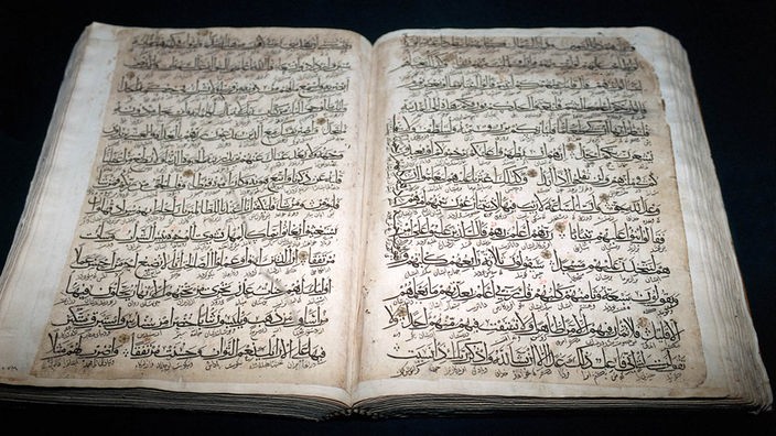 Ein aufgeschlagener Koran mit arabischen Schriftzeichen.