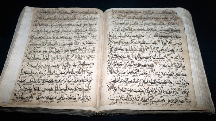 Ein aufgeschlagener Koran mit arabischen Schriftzeichen. | Bildquelle: dpa Ein aufgeschlagener Koran mit arabischen Schriftzeichen.