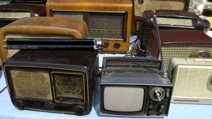 Auf einem Tisch sind verschiedene alte Radios ausgestellt