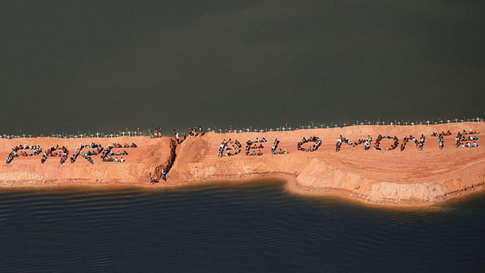 Einwohner sitzen auf Rohbau des Staudamms Belo Monte und protestieren
