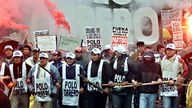 Demonstration in Argentinien 2001: Die Demonstranten sind mit Knüppeln bewaffnet und tragen Spruchbänder und Plakate. Im Hintergrund Rauchbomben und Feuer.