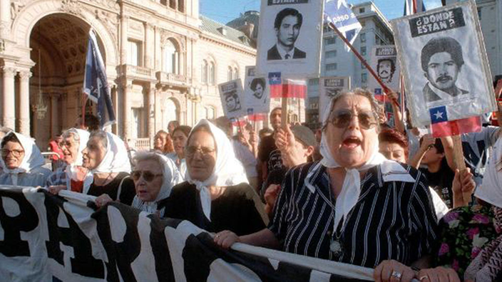 Demonstration mehrerer älterer Frauen mit Spruchbändern und Plakaten.
