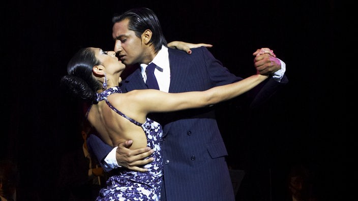 Ein Paar tanzt eng umschlungen Tango.