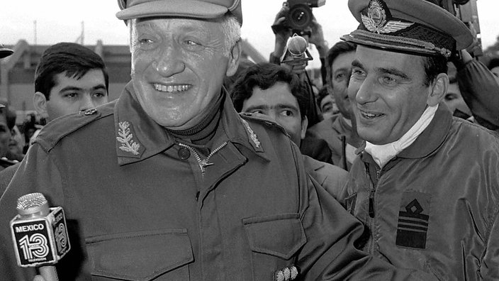 General Leopoldo Galtieri lacht bei einem Interview auf offener Straße in die Kamera. | Bildquelle: WDR / dpa Picture-Alliance / epa afp General Leopoldo Galtieri lacht bei einem Interview auf offener Straße in die Kamera.