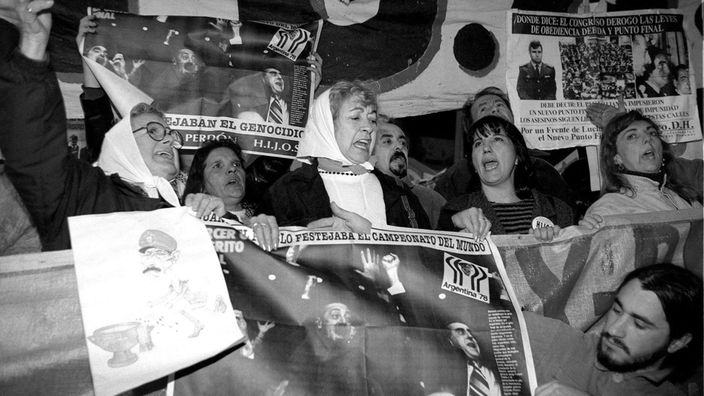 Schwarzweiß-Foto zahlreicher Frauen, die demonstrieren und dabei Plakate und Spruchbänder in die Höhe halten.