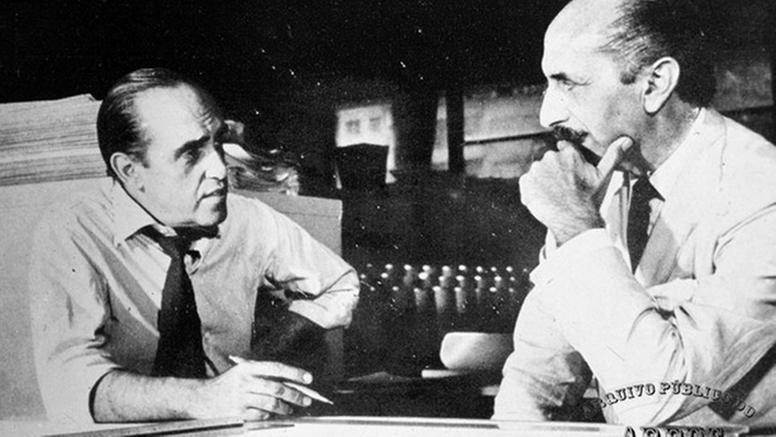 Schwarzweiß-Foto: Oscar Niemeyer und Lúcio Costa an einem Tisch.
