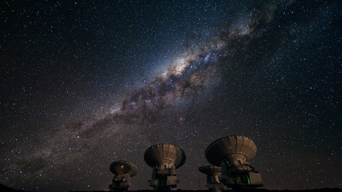 Verschiedene Radioteleskope zeigen auf den Sternenhimmel bei Nacht. | Bildquelle: ESO/José Fransisco Salgado Verschiedene Radioteleskope zeigen auf den Sternenhimmel bei Nacht.