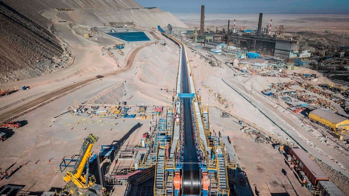 Die Mine Chuquicamata mit einem Förderband, Maschinen, einer Fabrik und Wasserbecken. | Bildquelle: AFP/Codelco/Olivier LLaneza Die Mine Chuquicamata mit einem Förderband, Maschinen, einer Fabrik und Wasserbecken.