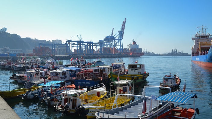 Mehrere farbenfrohe Boote und Schiffe befinden sich in einem Hafen.