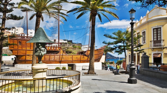 Zwischen zwei Häusern steht ein großes Holzsegelschiff mit zwei Masten | Bildquelle: Interfoto/The Travel Library Zwischen zwei Häusern steht ein großes Holzsegelschiff mit zwei Masten