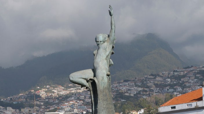 Das Denkmal für die Nelkenrevolution auf Madeira stellt einen Menschen dar, der sich aus einer Steinsäule in den Himmel streckt.