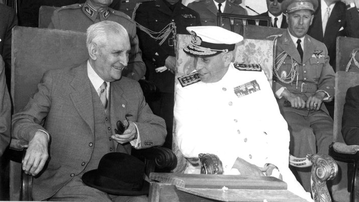 Der Diktator Salazar bei einer Militärparade 1961 im Gespräch mit dem Staatspräsidenten Thomaz auf der Tribüne. | Bildquelle: picture-alliance Der Diktator Salazar bei einer Militärparade 1961 im Gespräch mit dem Staatspräsidenten Thomaz auf der Tribüne.