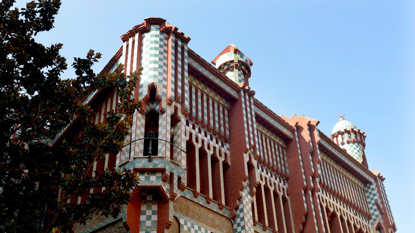 Fassade der Casa Vicens mit buntem Mosaik und runden Türmen
