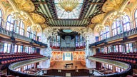 Saal des Konzerthauses mit großer Orgel über der Bühne, viel farbiges Glas und Mosaik